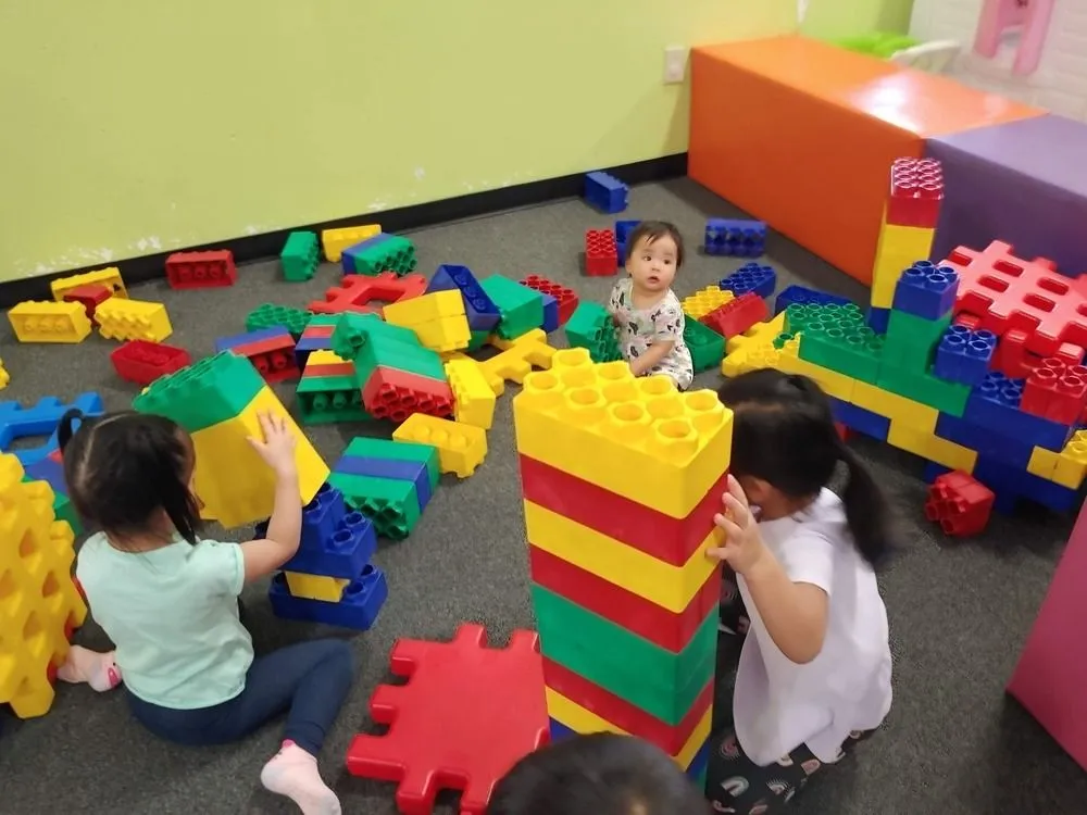 Young children playing together in the toddler-friendly block area at DinoDash